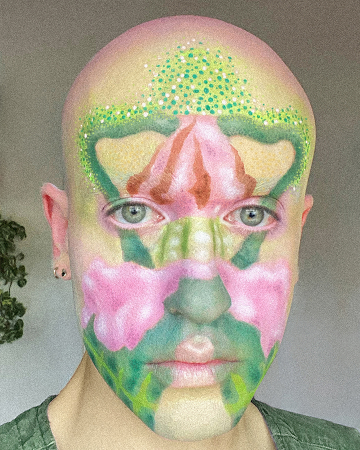 Close up portrait of Jesse Clark with artistic facepaint of a colorful fire poppy flower